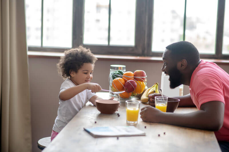 Father enjoying breakfast with his daughter.