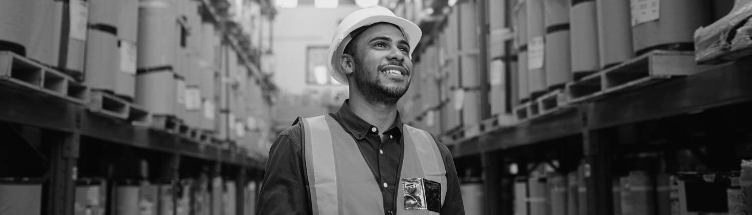 Male worker in a warehouse looking up and smiling