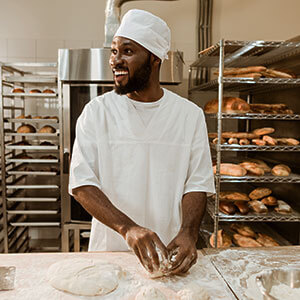 man kneading dough in a bakery.